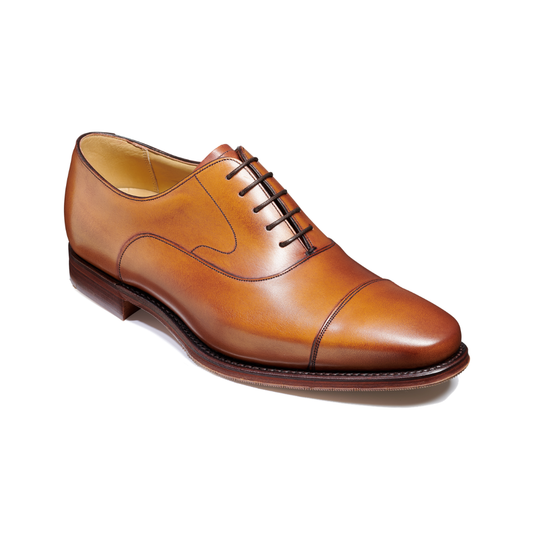 A classic men's cap-toe oxford shoe in polished cognac brown leather, featuring dark brown laces and a dark brown stacked heel, photographed on a clean white background.