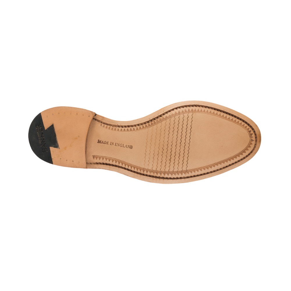 The outsole of a light tan leather shoe, showing the heel with a black rubber accent, the center with 'MADE IN ENGLAND' printed, and the toe with decorative stitching, on a white background.